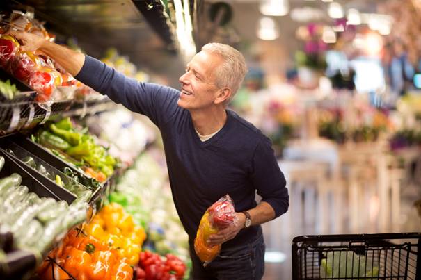Man picking up vegetables from a shelf
